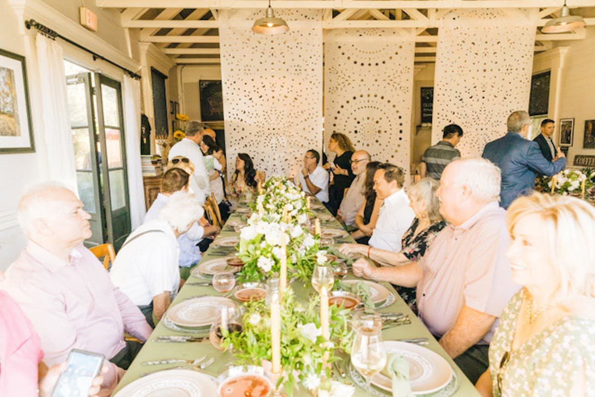 Guests seated at a long table in the historic indoor dining room